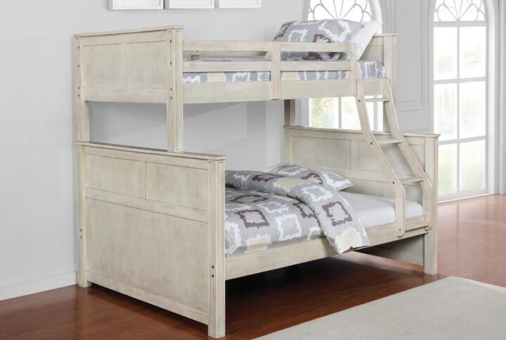 Give your children's bedroom a pastoral makeover with this modern rustic twin over full bunk bed. It's crafted in a gorgeous hand-brushed antique white finish that has a farmhouse appeal. Upper guardrails provide safety