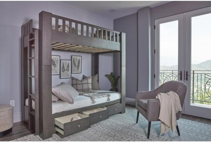 This towering twin over twin bunk bed is a majestic addition to any children's bedroom. It's crafted with an elegant antique grey finish that has instant appeal. Upper full-length guardrails provide safety
