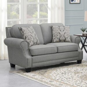 Indulge in a farmhouse transitional feel with a loveseat offering comfy seating and a designer vibe. This fabulous loveseat with its rolled arms and recessed sculpted arm panels trimmed in self-welt also delivers individual hand-driven antique nail heads and wood block feet. Sinuous springs in seat cushions set up a comfortable place to sit
