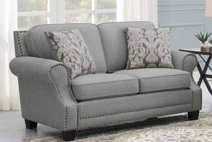 Indulge in a farmhouse transitional feel with a loveseat offering comfy seating and a designer vibe. This fabulous loveseat with its rolled arms and recessed sculpted arm panels trimmed in self-welt also delivers individual hand-driven antique nail heads and wood block feet. Sinuous springs in seat cushions set up a comfortable place to sit