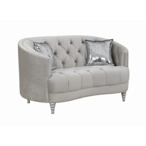This loveseat envelops you in romantic style and luxury. The button-tufted design is timeless and classic. The wraparound seat back curves down to convenient armrest. Sink into thick cushions for hours peace and quiet while huddled with a book or a partner. Comes finished in impressive grey material that perfectly suits the decor in any living room.