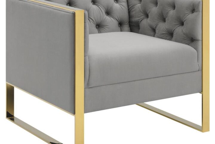 A blend of contrasting tones and materials will make this modern two-tone accent chair a mainstay in your home. It's upholstered in button tufted soft velvet in an elegant light grey finish that matches most any decor. A gold stainless steel base wraps around the arms and forms sturdy U-shaped legs. It's a feast for all your senses as you sit back and enjoy this cozy chair after a hard day. It's designed to be as at home in a modern living room or den as it is in an eclectic home library or entertainment room.