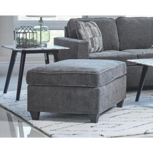 Prop your feet up or enjoy a temporary seat with this reversible transitional ottoman. But be aware - you may have competition from the family dog or cat for this comfortable accent piece. The plush dark grey chenille fabric cushion is accented with self-welt details for extra style. The dark brown tall tapered legs give the ottoman added height. It's ideal for use with your favorite sectional