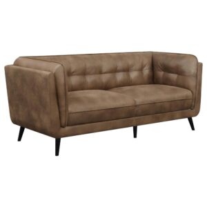 upholstered in a soft and smooth brown microfiber leather throughout its welt-trimmed and grid tufted seats and cushions. Plush and inviting with a bold vintage flair