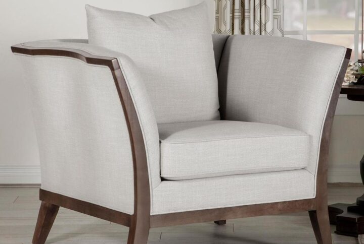 Relax in a den or living space with this transitional beige and wood accent chair