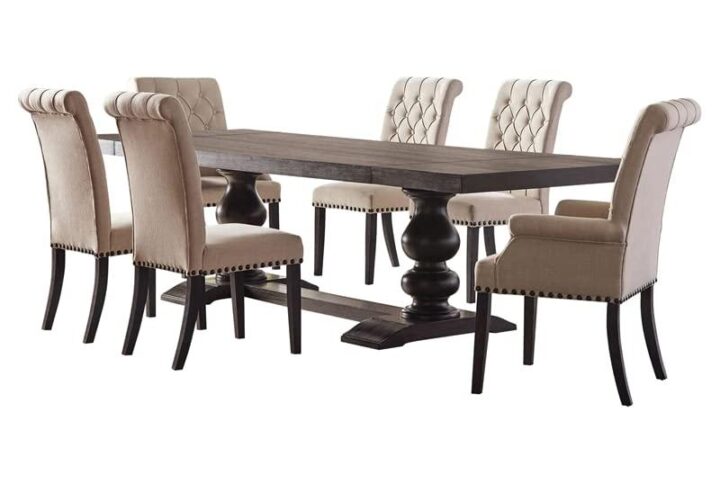 An exceptional dining set is inspired by European decor for a gorgeous dining space. The expansive rectangular tabletop is supported by a dual pedestal base with a stunning silhouette. Find upholstered dining chairs with a rolled backrest design for a traditional chest. The chairs are further enhanced with nailhead trim along with the frame. Supported on tapered legs