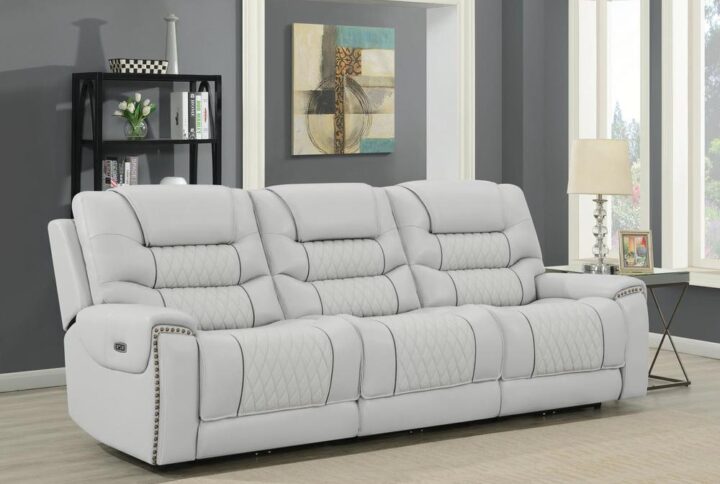 A chic and modern power sofa will change the look of your living space. The stunning upholstery is crafted from light grey top grain leather for an airy appearance. You'll adore the individually applied nailhead trim along the armrests for a traditional touch. The three power reclining seats with power headrests sofa lean back at the touch of a button with upholders available for your beverages. This appearance of this light grey dual power sofa is completed with stunning diamond print tufting.
