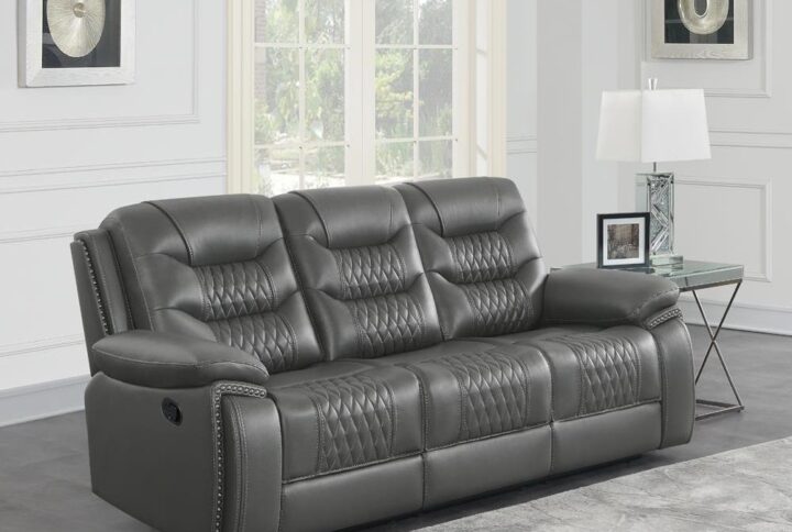 This motion sofa is wrapped in an upholstered in neutral tone performance leatherette all around