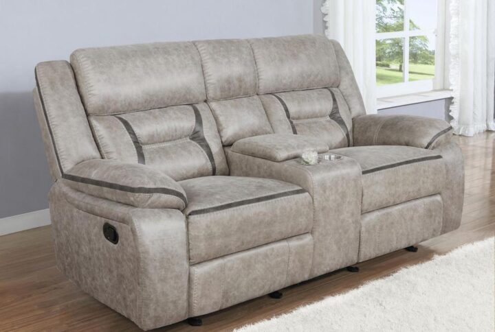 Every entertainment area deserves this glider loveseat with console. The neutral color palette makes it easy to blend with your decor. Its leatherette upholstery ensures a comfortable seating experience. A center console offers a small storage area for remotes with a lift-top container within. Find an easy place to store drinks with the built-in stainless steel cupholders.