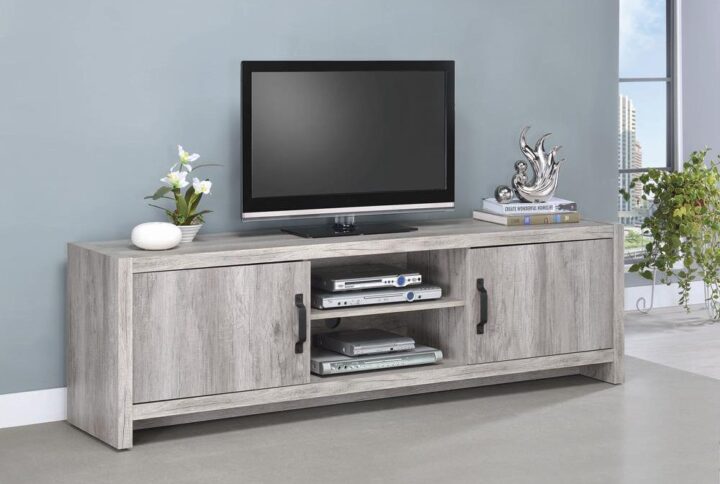 Stylize a modern space with light and airy attitude. Make this TV console a central focus in an entertaining space. A lovely grey driftwood finish reveals a natural grain effect. A spacious surface supports large-screen televisions