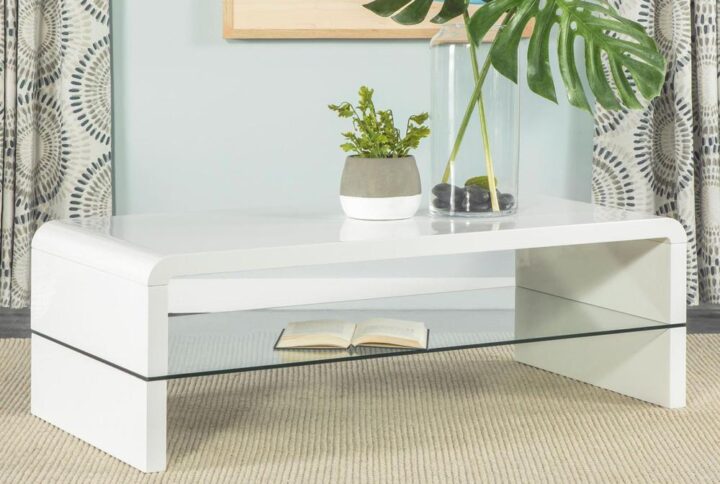 A smooth high-gloss finish and white tone lend a clean look to this modern coffee table. Designed with a rectangular tabletop that flows over an elegant waterfall edge into a plank-style base