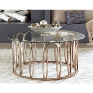 Enjoy an artistic flavor in the design of this light and airy coffee table. Charming bent and curved pieces encircle to create a ring shape base. A round glass top delivers tasteful elegance. With a whimsical silhouette
