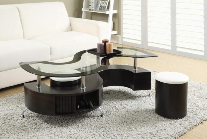 Revel in the contemporary charm of the sinuous curves from this coffee table and stool set. The serpentine silhouette of the occasional table features a glass table top with black edge trim. A sleek cappuccino and chrome finish adorn the base
