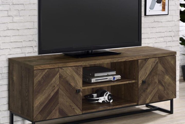 This rustic TV console offers a modern touch to a farmhouse style living room. A rustic oak finish showcases the classic herringbone pattern across the double cabinet doors. Supported on a metal trestle base in a gunmetal finish that offers an industrial flair