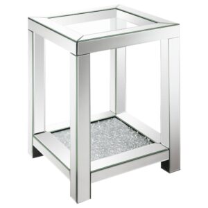 this glam end table offers up true Hollywood regency vibes. Beveled mirror trim offers a classic touch while a sparkling acrylic jewel-encrusted bottom shelf lends a modern flair to this chic