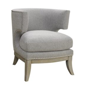 This distinctive accent armchair is designed to stand out in any room of the home. It's built with a barrel back and high armrests that look impressive. Stylishly decorated with nailhead trim along the frame and side cutout beneath the armrests. Flared legs are finished in a weathered grey. It's wrapped in cool grey chenille that suits any living room or entertainment room decor.