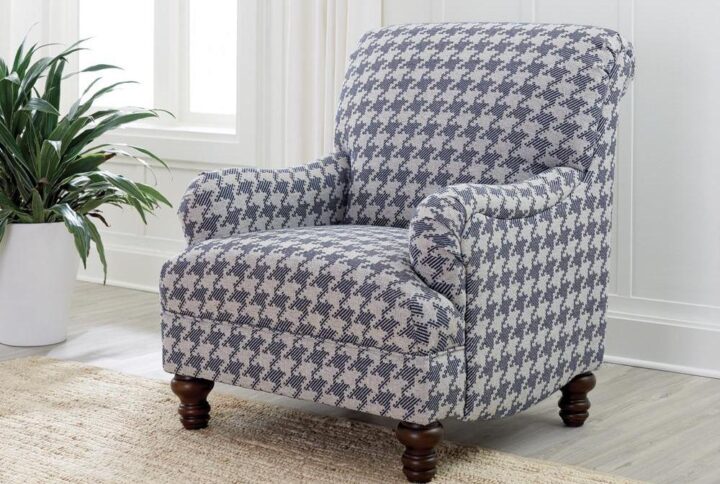 A standout houndstooth check pattern draws due attention to this fashionable accent chair. With tailored English arms and turned legs offering a contrasting espresso finish