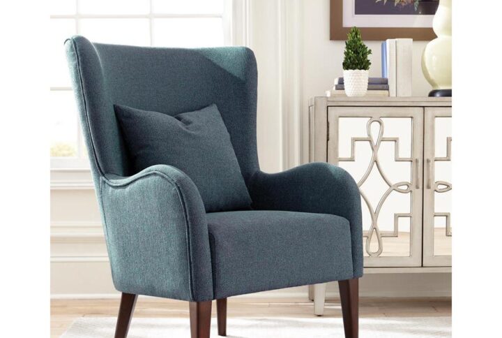 This accent chair has a traditional look with a bit of distinction. It's constructed with a high back and curved arms for a charming silhouette. It features a thick seat cushion and pillow that can serve as lumbar support. Legs are flared in the back and come with a dark finish that's a handsome contrast for the blue upholstery. This chair looks great in a bright living room or a home library.