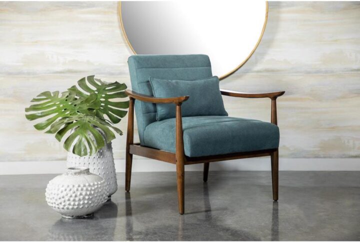 Soft upholstery and natural elements combine to create a striking accent chair. Its teal color gives it an interesting aesthetic vibe with cashmere-like upholstery. The natural wood frame of this armchair enhances the teal fabric. A matching supportive pillow comes included for additional support. This accent chair can easily enhance eclectic living spaces with a mid-century modern design.