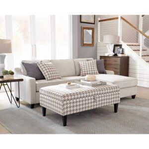 its height and width also make for a convenient use as a temporary coffee table with room for a serving tray or magazines. It's upholstered in beige and white gingham-style fabric. With legs finished in dark