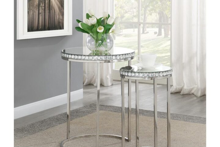 Add a sense of sparkle to your space with this set of two silver nesting tables. The stainless steel base provides a bold and durable upgrade. The round tabletops are perfect for placing beverages and small items. Sparkling gemstones surround the frame for an exciting sense of glitz and glam. A combination of steel and glass makes these nesting tables a striking addition in your home.