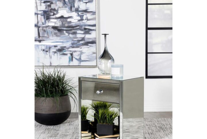 Sleek reflective surfaces elevate the modern glam look of this contemporary accent table. Covered entirely in mirror trim and paneling