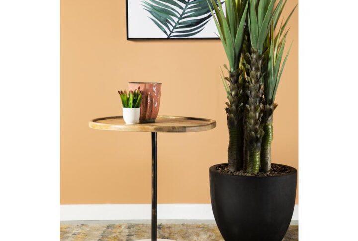 A marvelous mango wood accent table provides a mix of materials for visual interest as the round wood tabletop in a natural finish provides a spot for displaying decor. A durable metal frame keeps the tabletop and base securely in place. A striking and contrasting white marble base provides plenty of stability. Place this piece near a window with a house plant or place it beside your favorite armchair. Include this marble