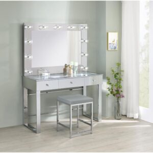 this modern vanity set features a stunning mirror paneled design that reflects surrounding hues. Cleverly designed with a clear tempered glass top that showcases cosmetics and accessories tucked inside the three drawers beneath