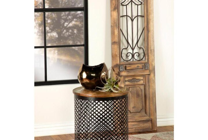 Rustic elements collide with classical designs in this industrial style accent table. Featuring a drum shape base wrapped in a perforated metal latticework grid with quatrefoil motif