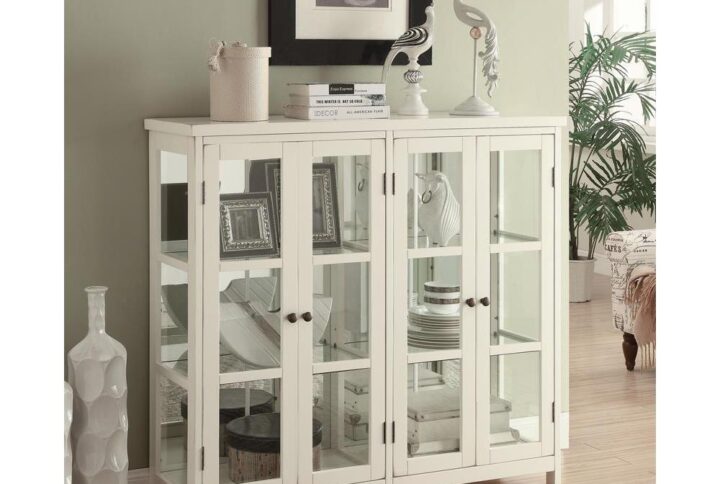 This accent cabinet is sure to get noticed with its transitional styling and expert craftsmanship. It's handsomely crafted with glass panels on the sides and doors. The four large doors open up to glass shelves inside