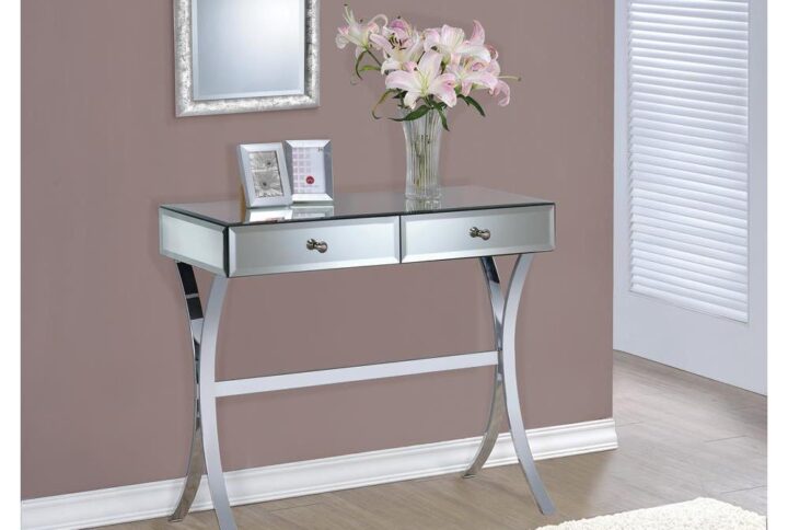 Add this console table to the home for an alluring brilliance and shine. It features two spacious drawers for convenient storage. Wide table top accommodates a decorative table lamp and knickknacks. It features gorgeous curved legs that add a touch of class. Table is beautifully covered in mirror panels with chrome-finished frame and legs for a modern look.