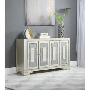 A glam style accent table is a treat for any eye to meet. Four cabinet doors make this a roomy and spacious essential for storing items. Take note of the gorgeous crystal-like round knobs. The accent table's champagne finish and mirrored cabinet panels will immediately accent your decor. Bracket style legs add to its aesthetic appeal while providing support.