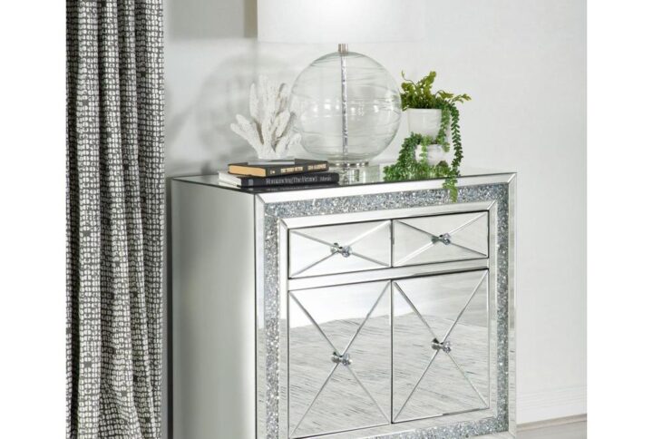 Shimmering accents and polished elements come together in this glam accent cabinet. Covered entirely in clear mirror surfaces and beveled mirror trim and tile
