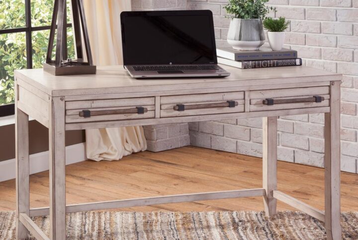 The Aurora Writing Desk has rustic character paired with industrial features in a whitewashed finish for today's casual lifestyle.  Sturdily constructed of kiln-dried hardwoods and veneers with three drawers featuring ball bearing side guides for smooth operation.