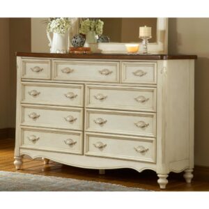 framed with veneers in a soft antique white with intentional distressing and sporting a top finished in a warm brown. The piece stands just over 41” tall and features nine drawers with dovetail joints and double or center guides with positive stops