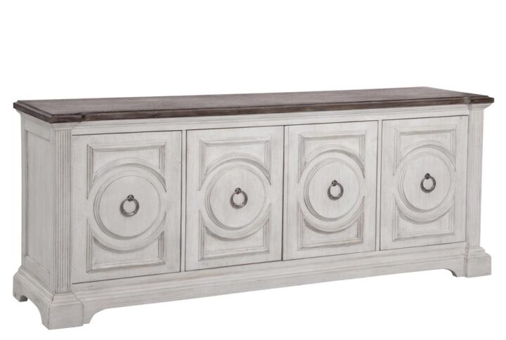 Experience southern charm with a modern twist when you choose the Brighten 84" Console.  The heavily distressed antique white finish is complemented by the antique charcoal tops and modern pewter ring door pulls.  Architectural pilasters frame the pieces and enhance the transitional circular designs and raised moldings of the door fronts.  This entertainment console features four spacious cabinets