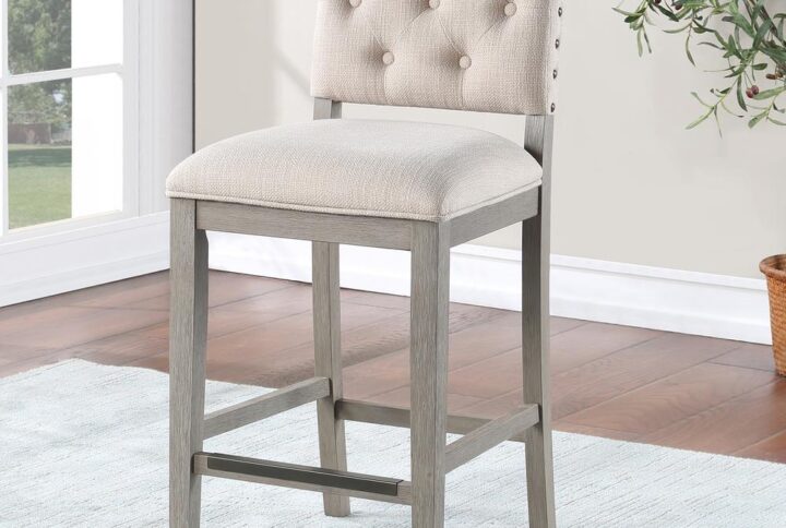 Comfort awaits with the stylish Ellesse Counter Height Stool with a solid hardwood frame finished in a weathered gray with easy to care for cream polyester fabric upholstery on the seat and back.   Stylish welted seams