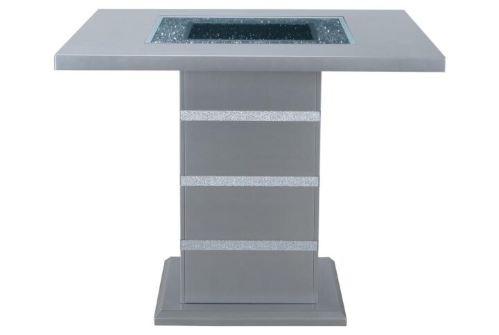 This bar table is a showcase example of how charm and a touch of elegance can dramatically change the look of your eating area. This table includes glitter detailing style elements with a sturdy construction and a high gloss finish with a clear glass inlay to round off the look. Constructed of MDF