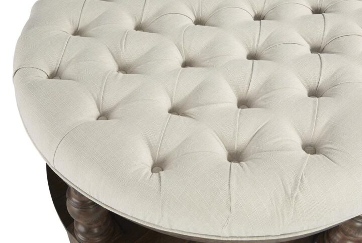 Casters includedRound cocktail upholstered and button tufted in a gorgeous cream colored woven fabricRubberwood construction assures great stability