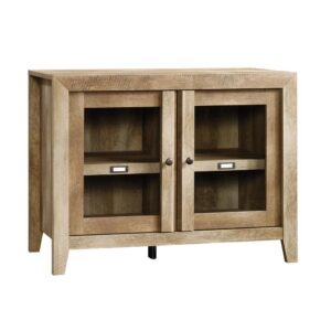 Take a pass on the ordinary. The perfect sideboard / storage cabinet for showcasing items on top while displaying more behind glass doors inside the cabinet. Make a bold statement with this display cabinet from the Dakota Pass® collection. Finished in traditional rustic country Craftsman Oak® and detailed with a contemporary sensibility. This functional storage credenza includes an adjustable shelf and can hold up to a 42" TV on top. Get inspired with this perfect solution for any room of the home.