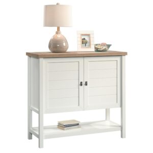 Need a solution for your clutter and chaos? Check out this storage cabinet from the Cottage Road® collection. This bright and airy cabinet features hidden storage behind each of the doors along with two adjustable shelves for enhanced storage possibilities. It also features a lower open shelf for additional storage! Finished on all sides in Soft White® with a Lintel Oak® accent