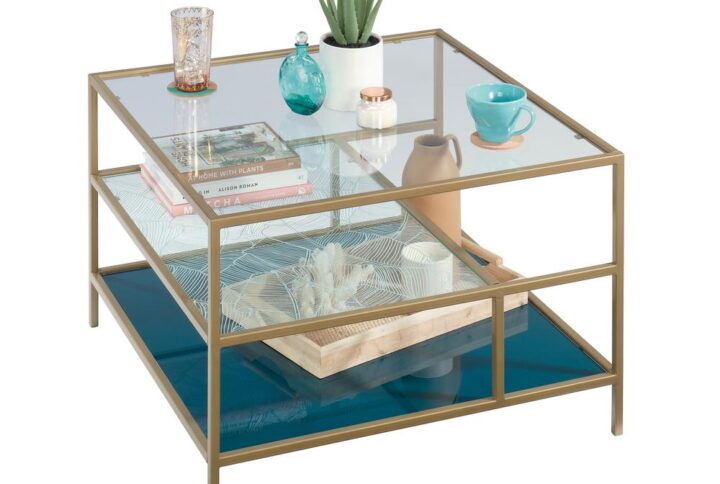 Create a centerpiece in your living room that will wow all your guests with the coastal-inspired style and unique design of this square glass coffee table from the Coral Cape® collection. This one-of-a-kind glass and metal coffee table features three safety-tempered glass shelves. The middle shelf features a banana leaf abstract pattern and the lower shelf features teal tinted silk-screened glass that is sure to stand out. Its spacious top surface provides you with room for items like stacks of magazines