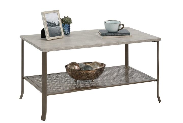 Creating a beautiful centerpiece in your living room has never been easier. Give your home the style it's been longing for when you add the charming good looks of this wood and metal coffee table from the Center City® collection. This living room coffee table with a shelf offers a spacious top surface that provides you with the room you need to store and display items like the TV remote