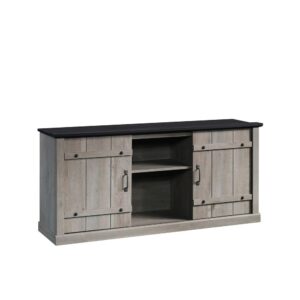 and it's not going anywhere. This modern farmhouse TV stand from the Sauder Select collection reminds you of simpler times with rustic charm and unique design. This TV credenza accommodates up to a 70" TV weighing up to 95 lbs.