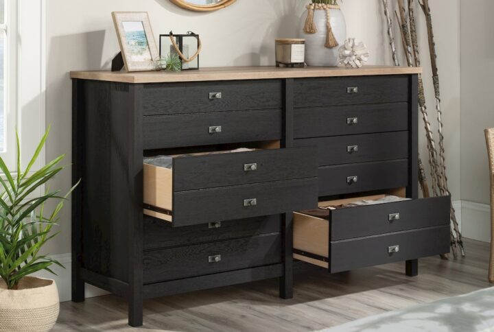 A modern dresser should have style and function at the forefront of its design. This 6-drawer dresser from the Cottage Road® collection does just that. This bedroom dresser features six spacious drawers that open and close on smooth metal runners for easy access storage of a variety of different items: from stacks of slacks and button-up shirts to your collection of leggings and cozy sweatshirts. Each drawer is detailed with attractive hardware that gives it an extra touch of style. The spacious top surface of this double dresser provides you with additional space to store other bedroom essentials and display home décor items like an accent lamp