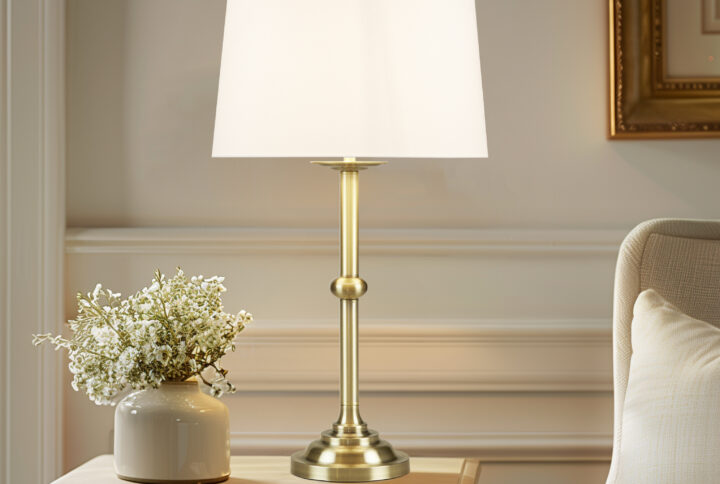 Add a touch of elegance to your living space with this beautiful Aelorian table lamp from the Bedford collection by Martha Stewart. This classic lamp features an antique brass finish and an empire fabric shade in off-white color. The on/off rotary switch is on socket and the lamp plugs in