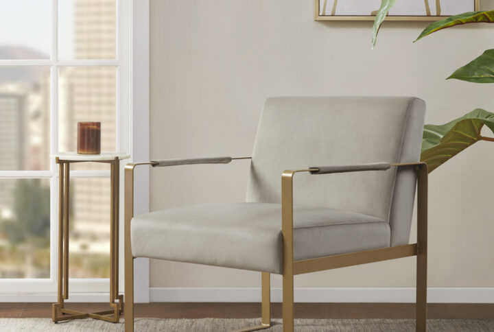 Elevate your living room decor with the luxurious style of the Martha Stewart Jayco Accent Chair from Perry Street collection. The seat and back are upholstered in a rich plush fabric that is complemented by the antique gold metal arms and legs