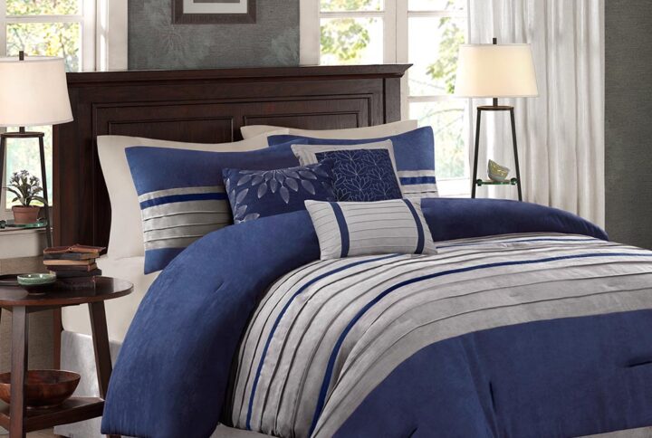 The Madison Park Palmer 7 Piece Comforter Set offers a classic and refined update to your bedroom decor. This transitional style comforter features a pieced microsuede design in rich contrasting blue and grey colors to create an incredibly soft look and feel. The 2 matching shams also flaunt a pieced construction to coordinate with the faux suede comforter. A solid grey bed skirt and 3 decorative pillows with a mix of embroidered designs add the perfect finishing touches to complete this lush traditionally-inspired comforter. Machine washable for easy care