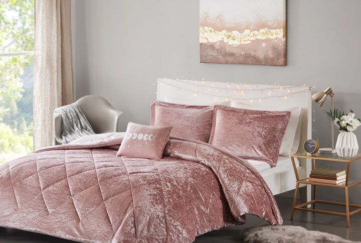 Create a lush and relaxing atmosphere in your bedroom with the Intelligent Design Felicia Velvet Comforter Set. The blush comforter is made from crushed velvet and features diamond quilting for a luxurious look. Matching crushed velvet sham(s) and an oblong decorative pillow complement the comforter to complete the modern style bedding set. Machine washable for easy care