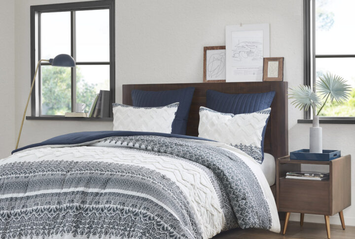 Transform your bedroom with the charming shabby chic allure of the INK+IVY Mila 3 Piece Cotton Comforter Set with Chenille Tufting. The cotton comforter flaunts an updated navy botanic print